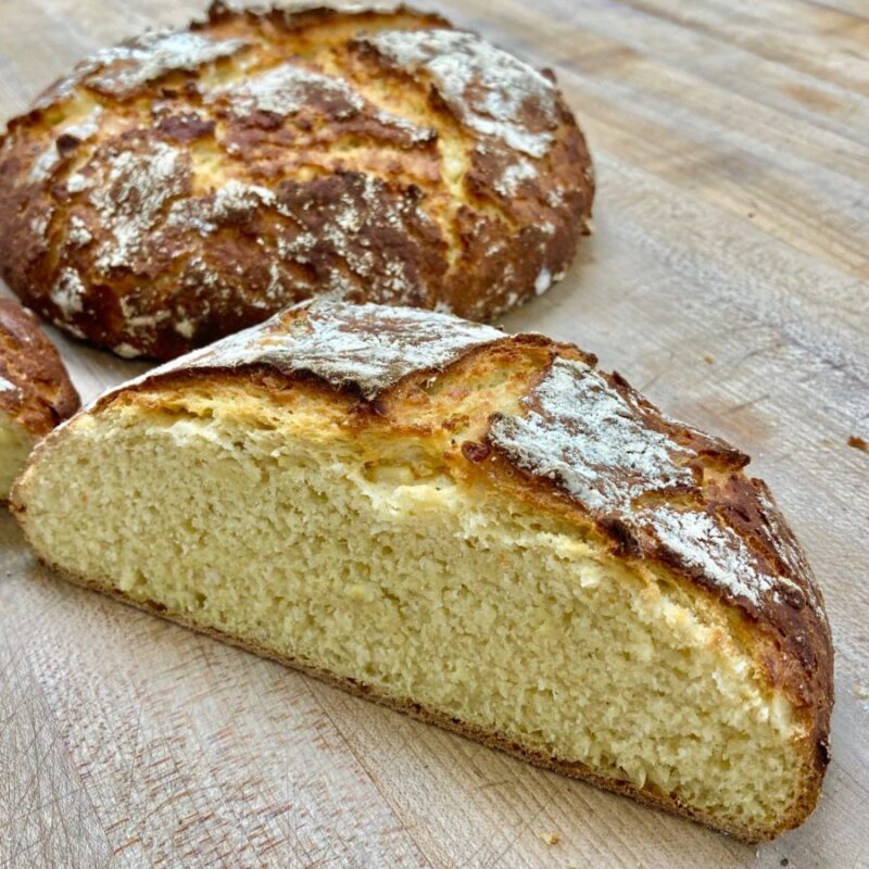 cut loaf of cornbread on wooden cutting board